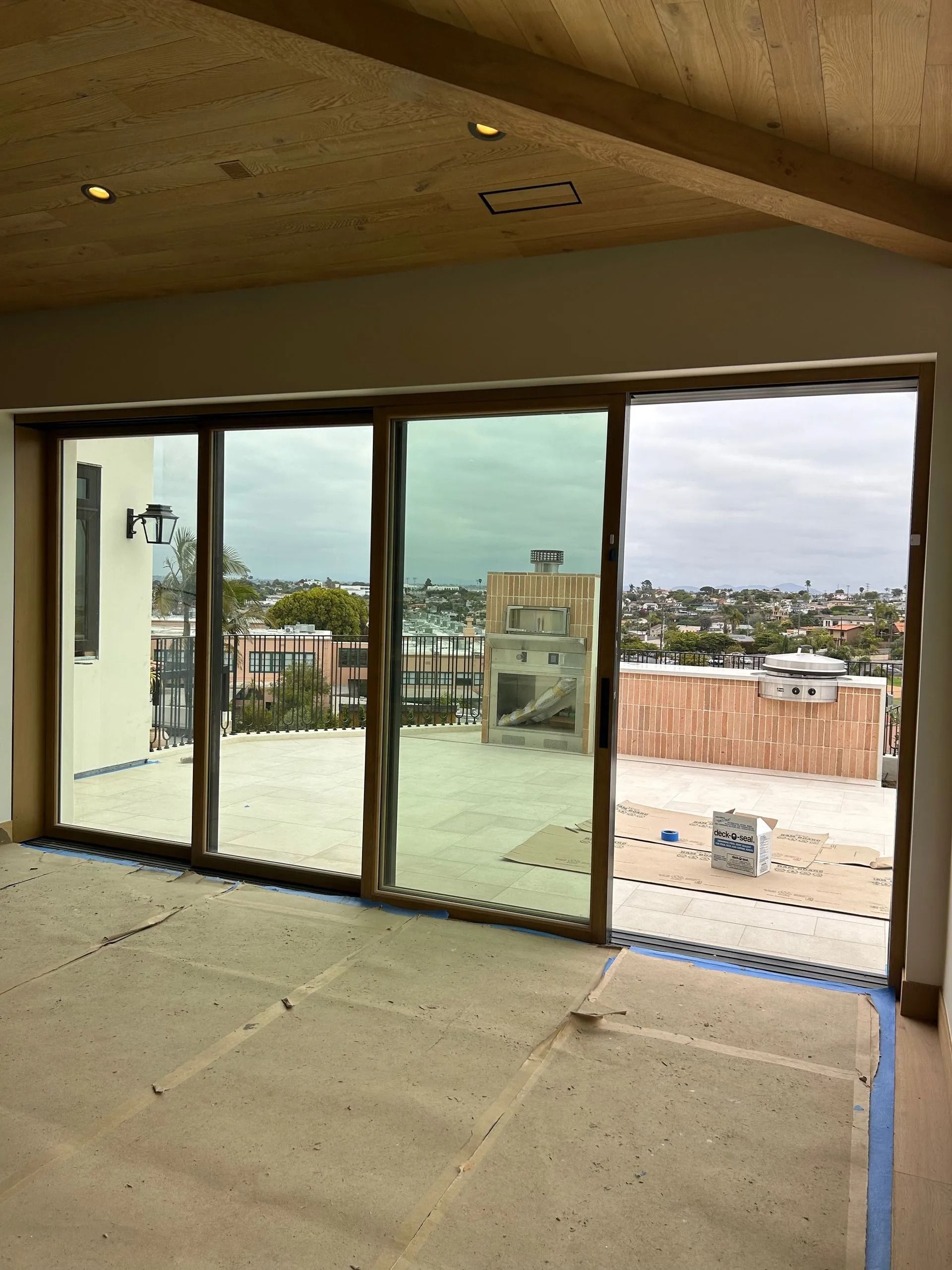 Interior view of a room with large sliding glass doors overlooking a cityscape and construction site.