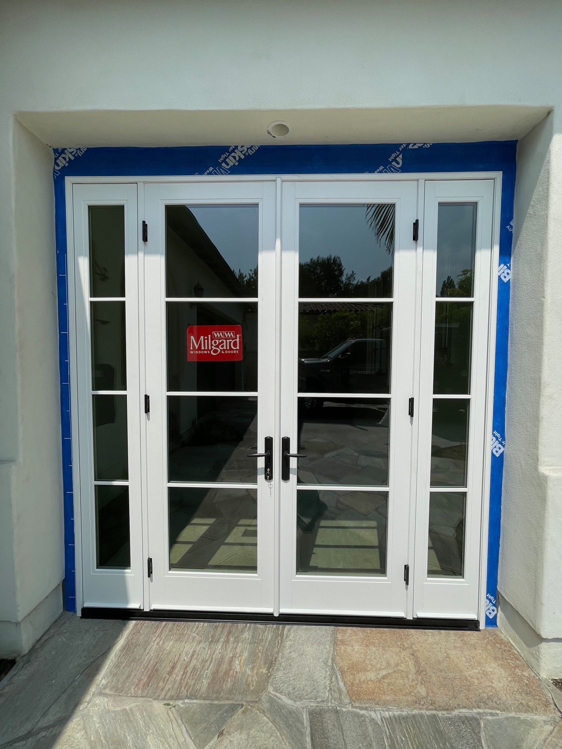 White French doors with glass panes, black handles, and a red 