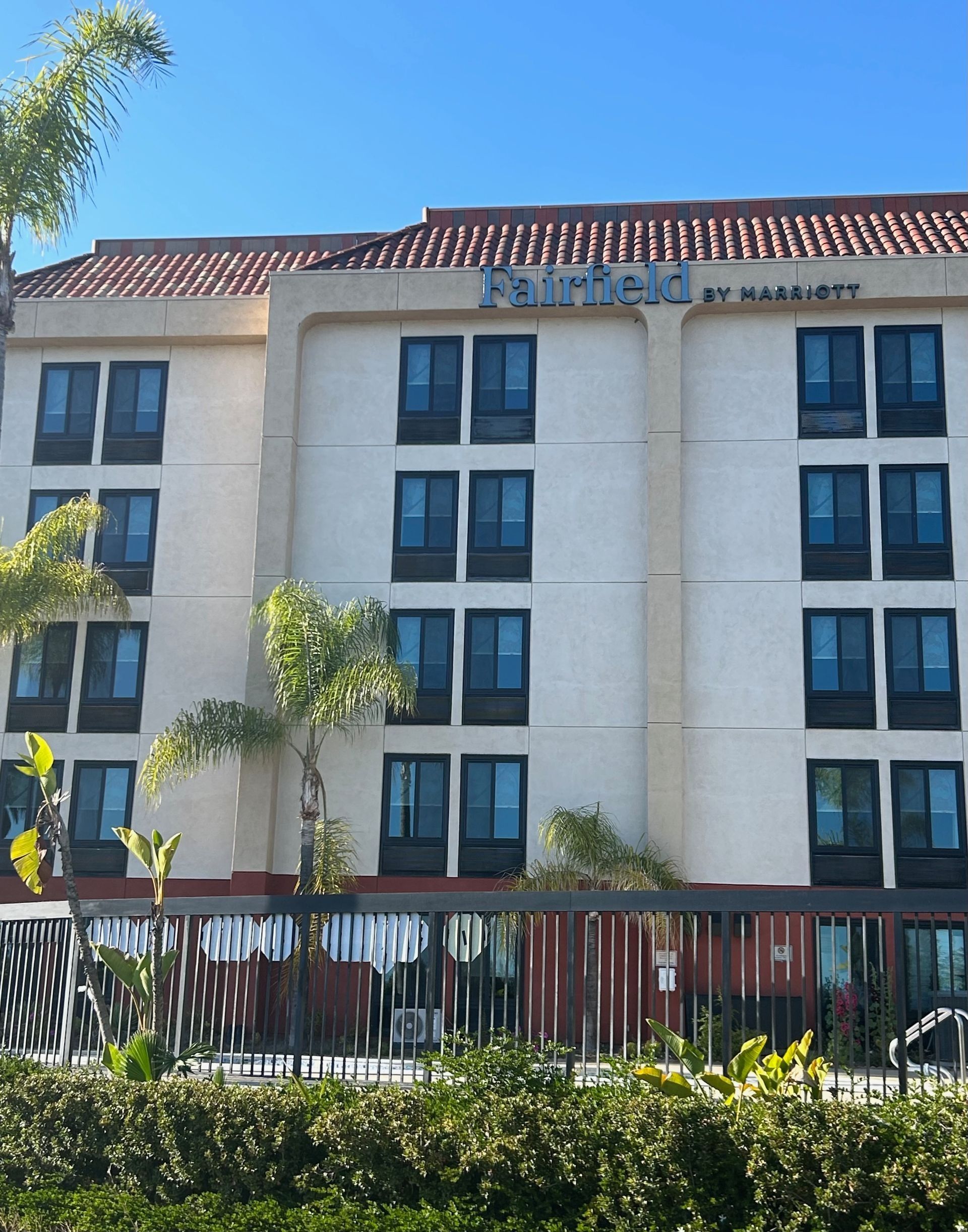 Fairfield by Marriott hotel exterior with beige walls, brown roof, and blue sky.