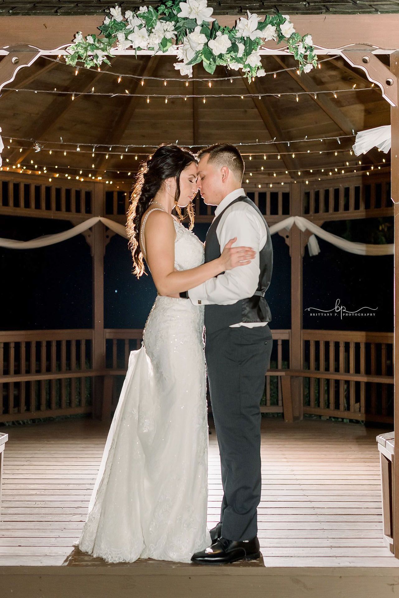 Couple embracing on a lit wooden gazebo