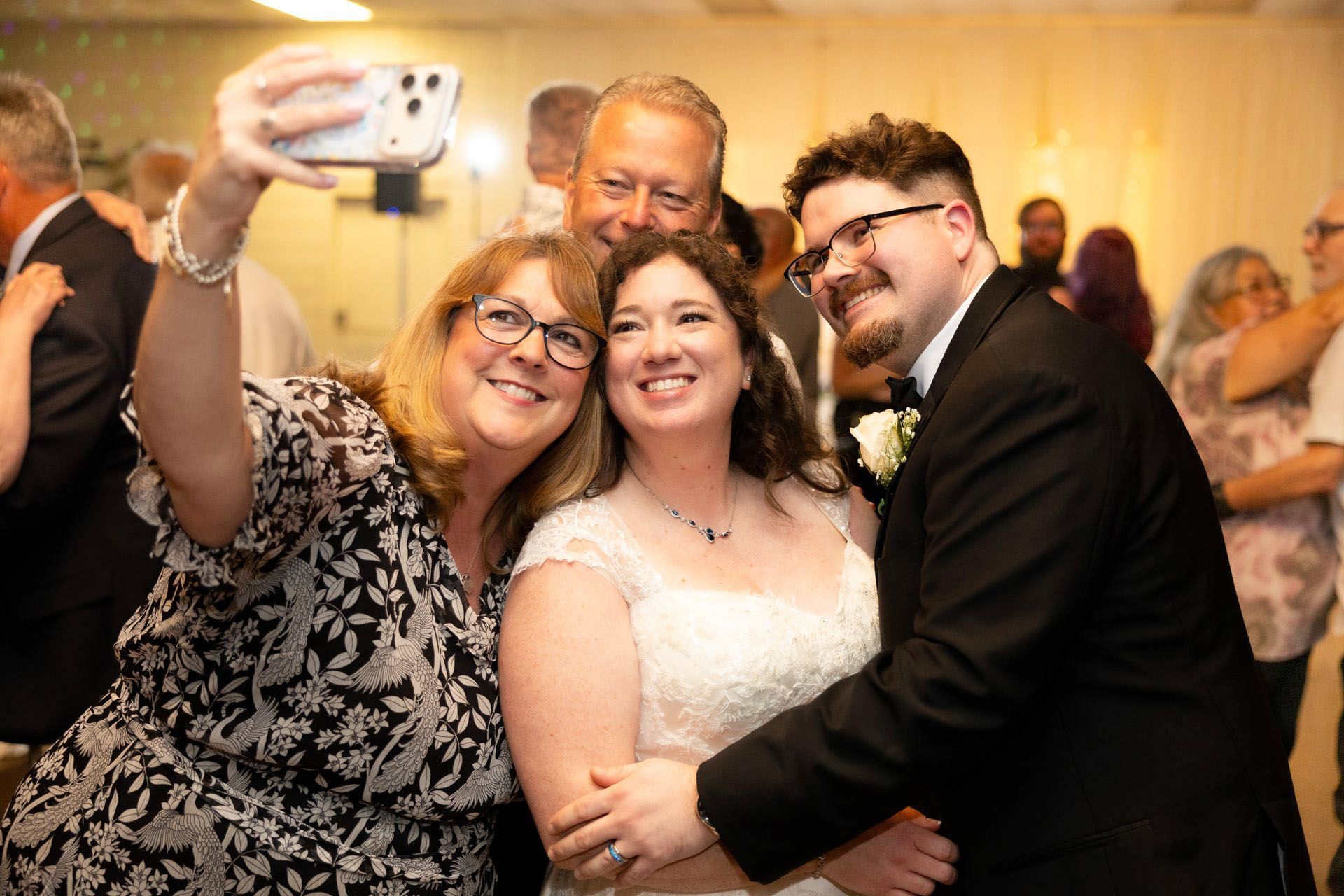 People smiling and posing for a selfie at an indoor event