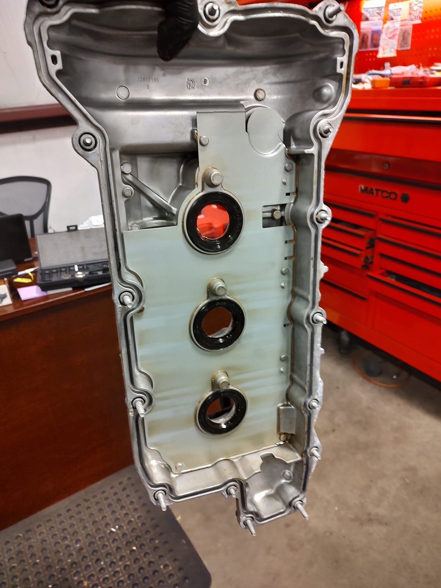 A close up of a valve cover with three holes in it