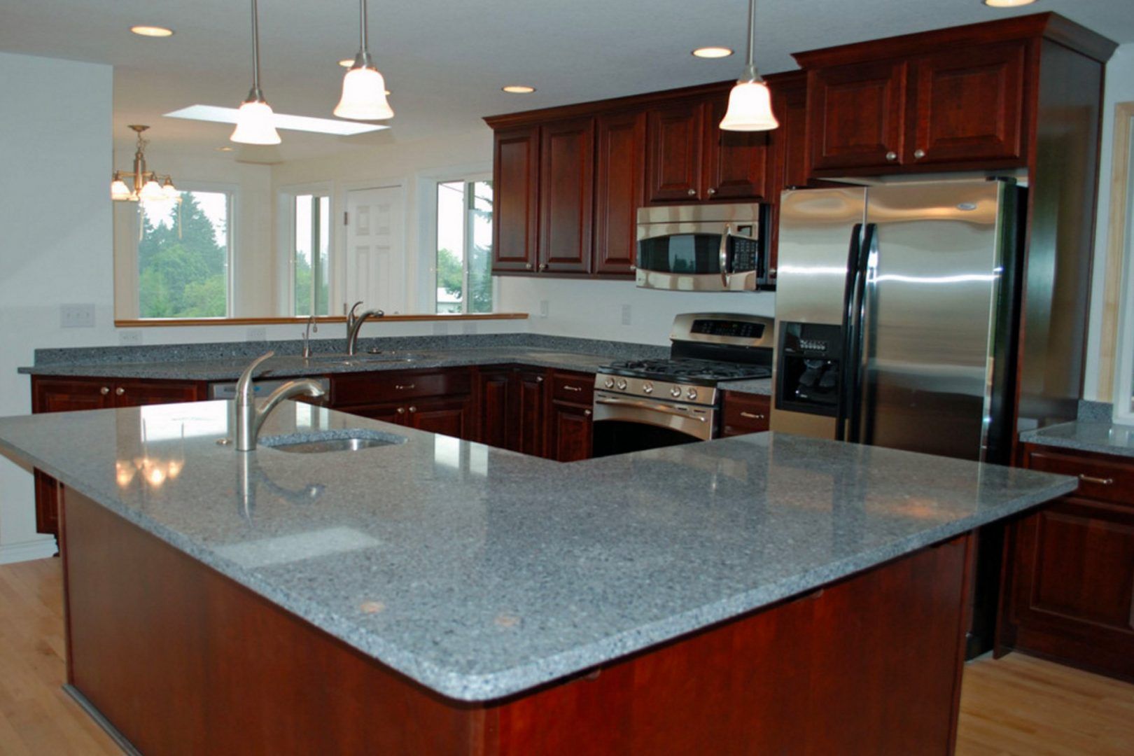 Kitchen with dark wood cabinets, stainless steel appliances, and granite countertops.