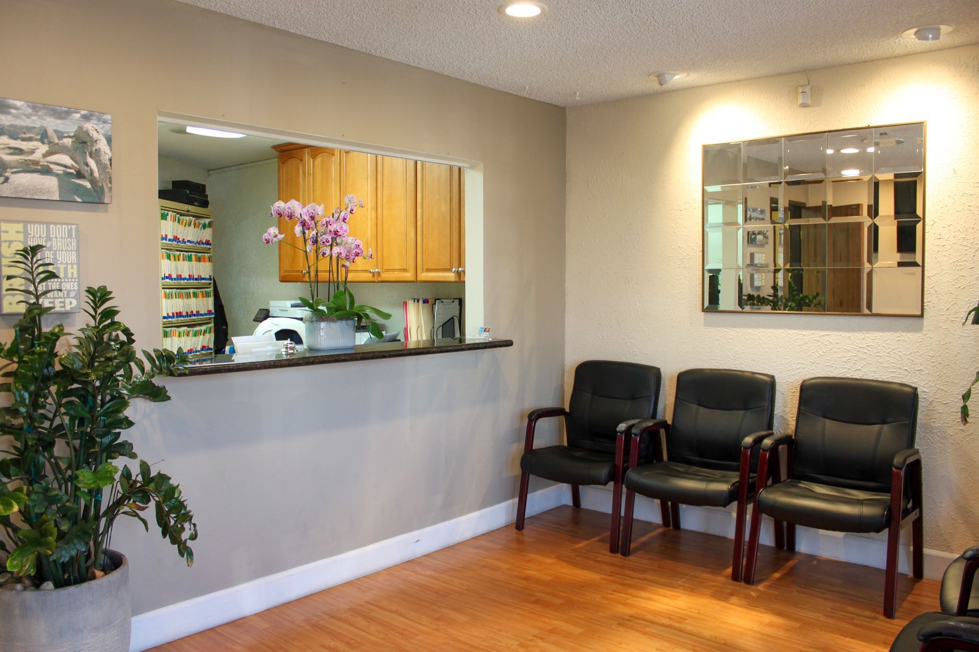 A waiting room with chairs and a counter in a dental office