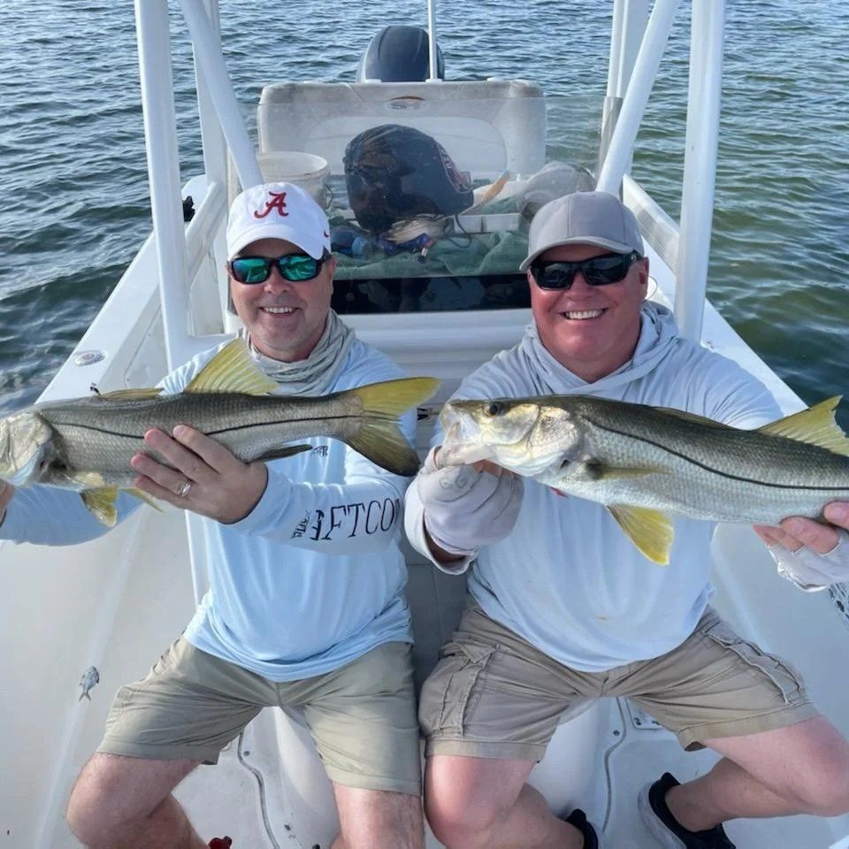 men with cap holding angler catch