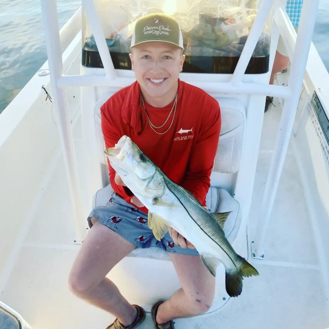 young man in red holding angler catch