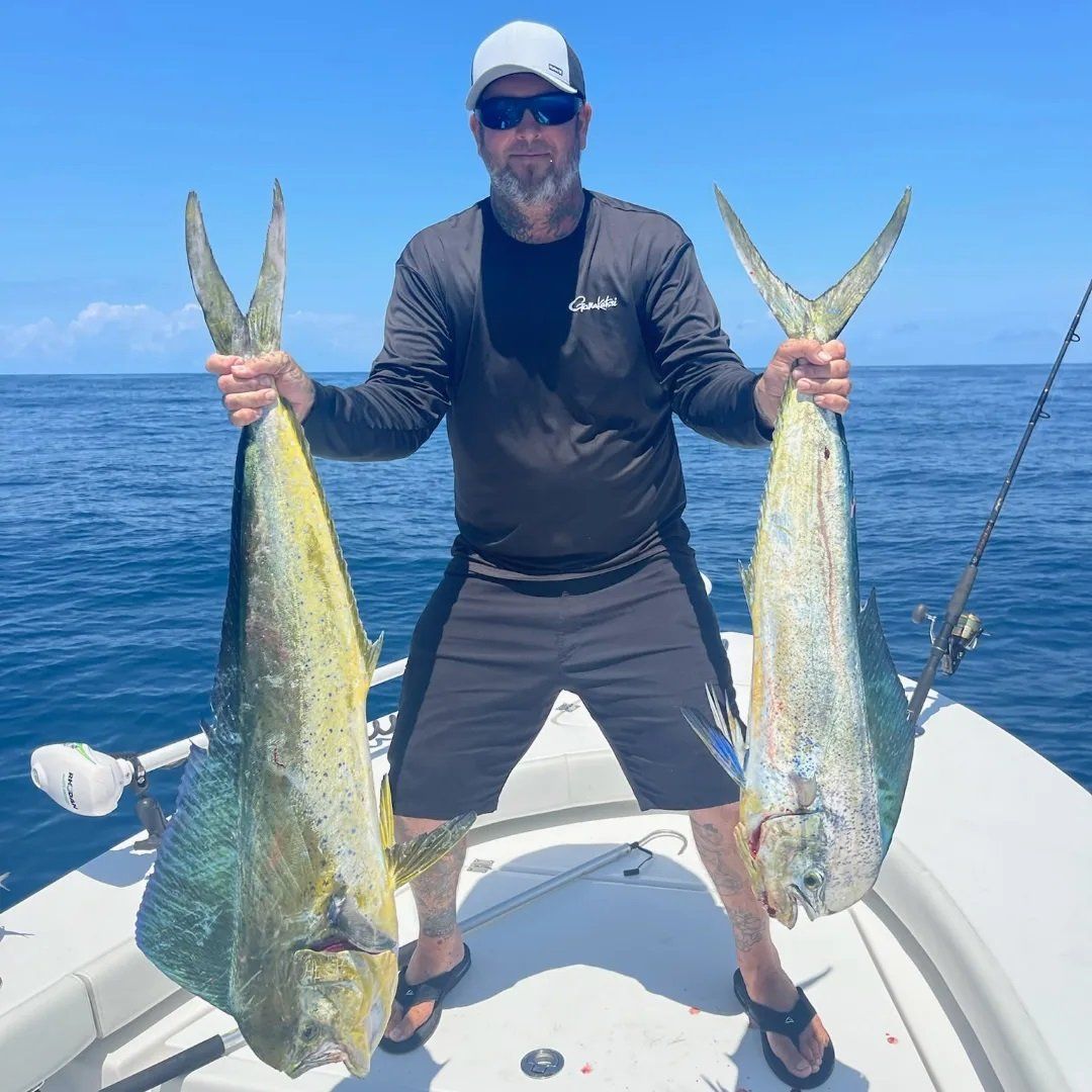 standing man holding his angler catch