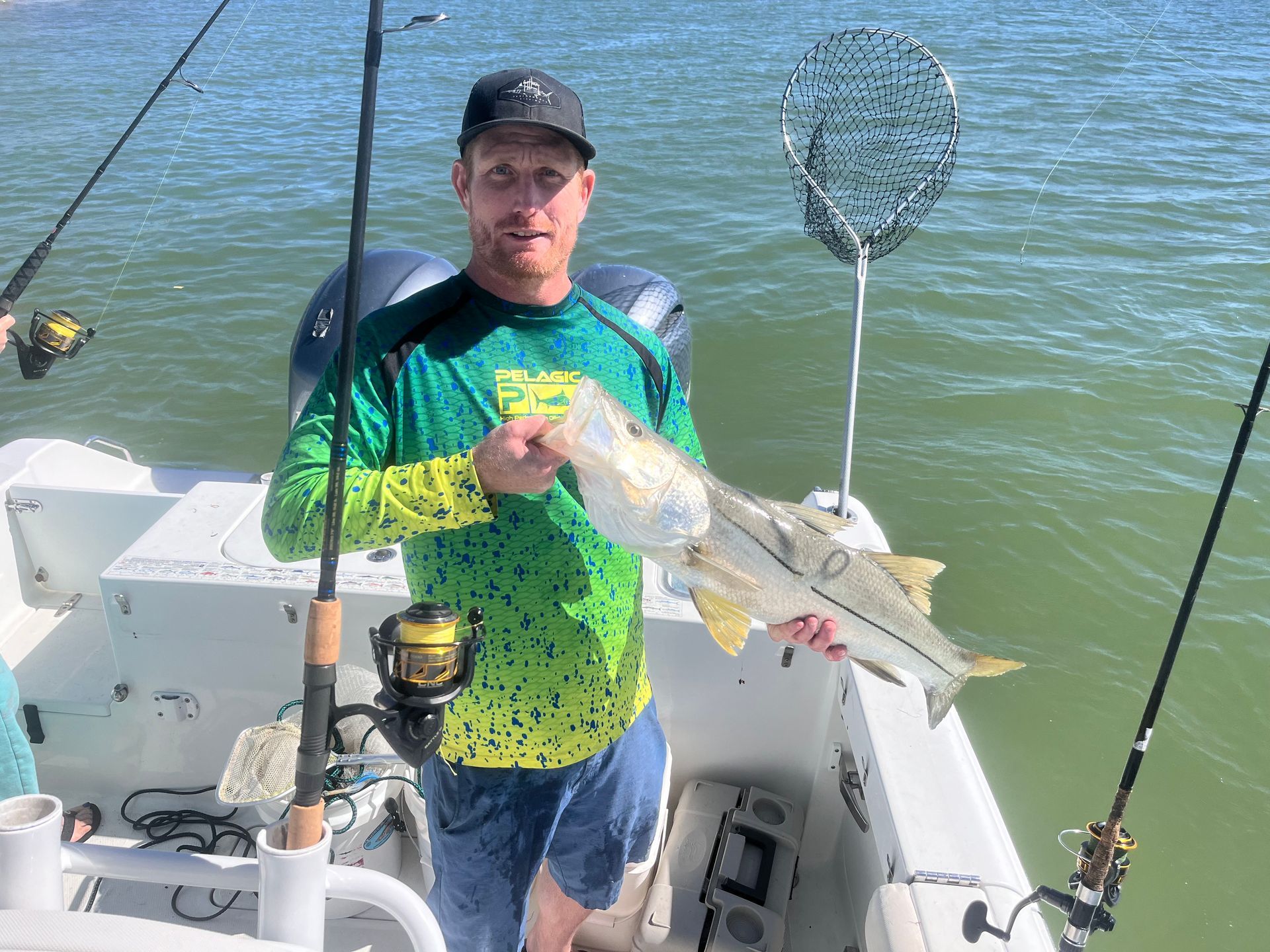 A man is standing on a boat holding a fish