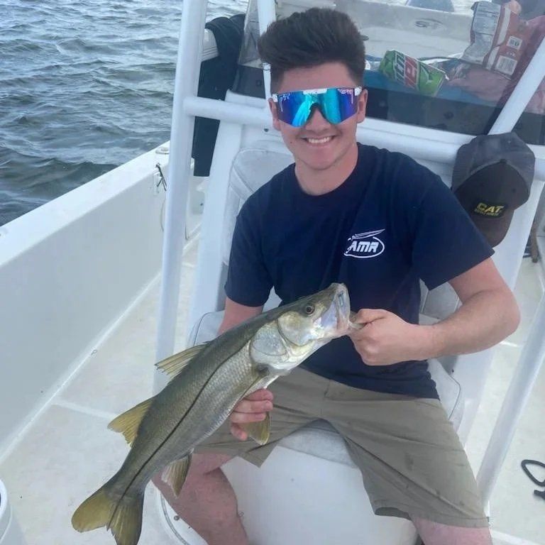 man blue shirt and shades catch fish