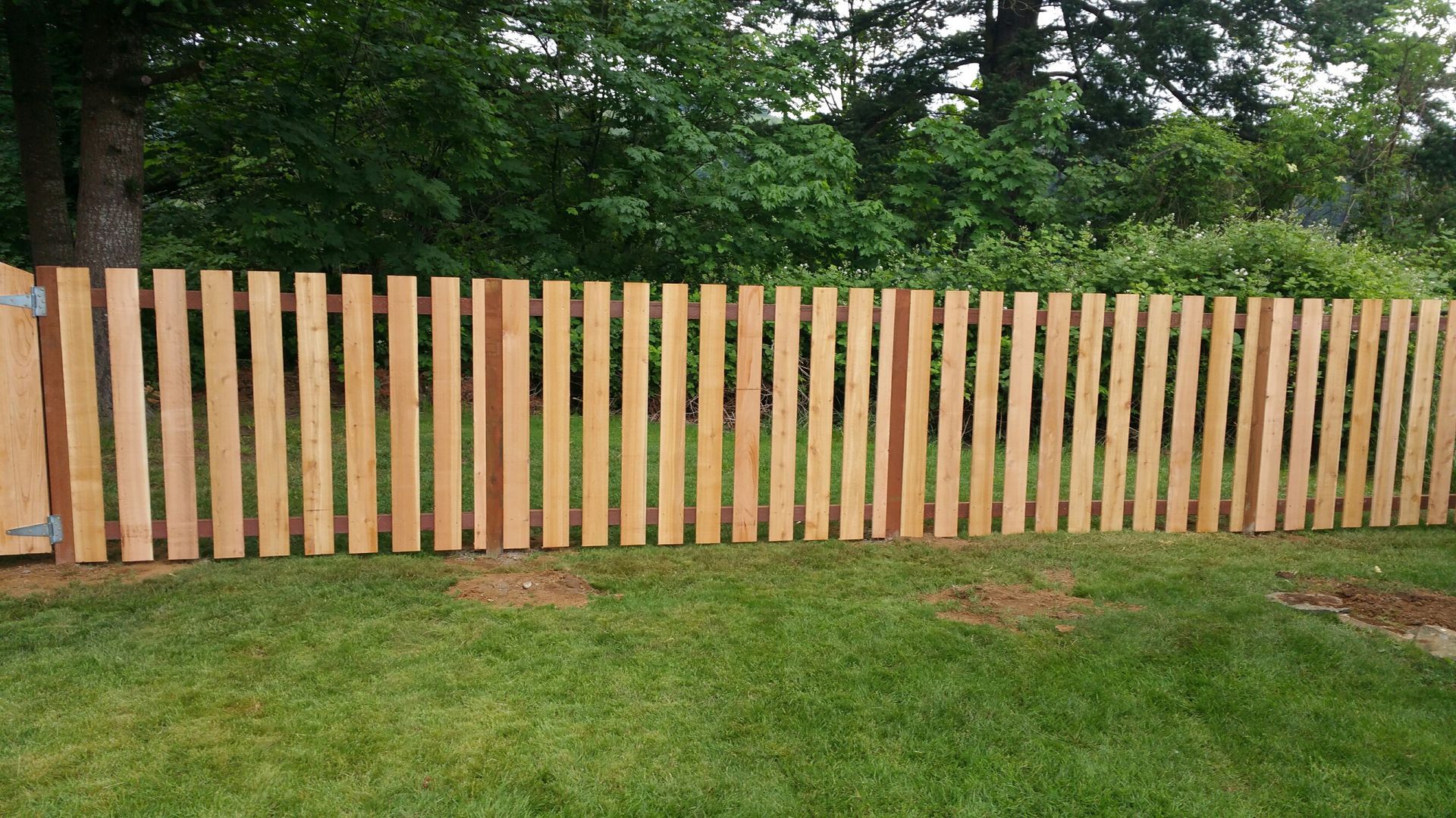 A wooden fence is sitting on top of a  lawn