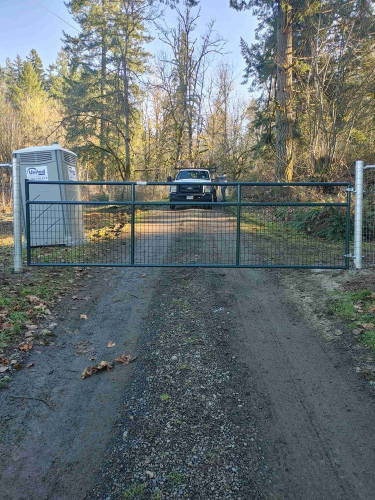 A truck is driving through a gate on a dirt road