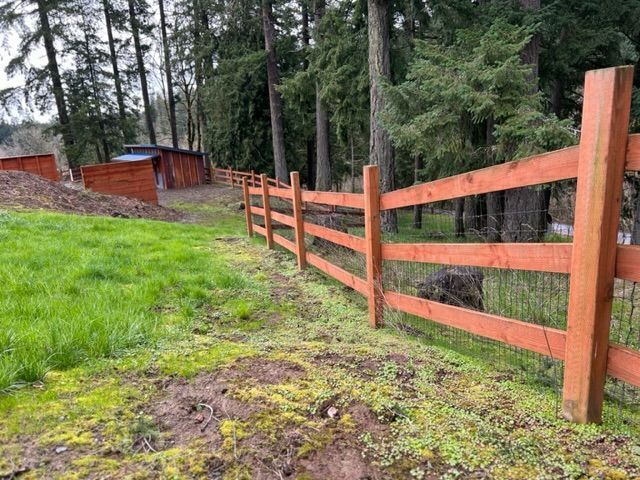 A wooden fence surrounds a grassy field