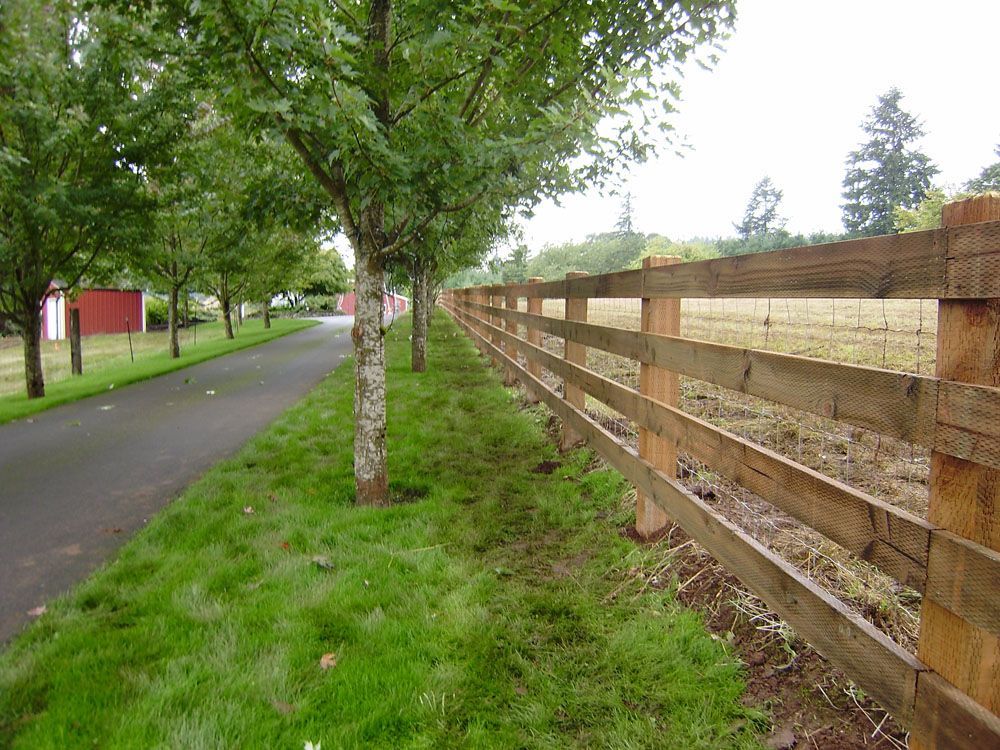 A wooden fence is along the side of a road