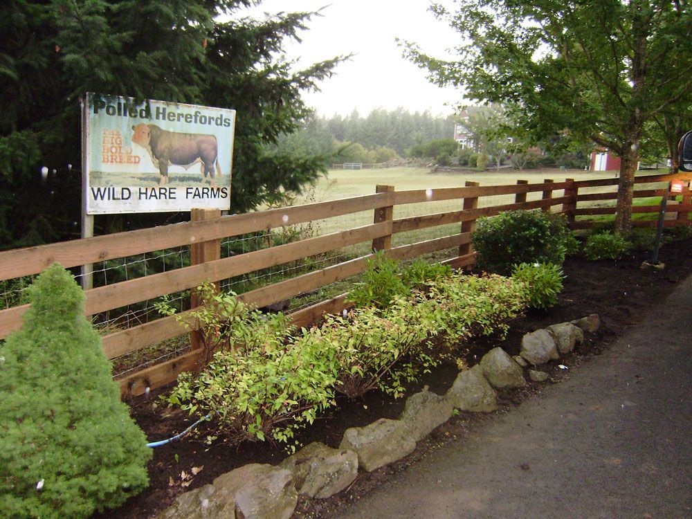 A wooden fence with a sign that says wild hare farms