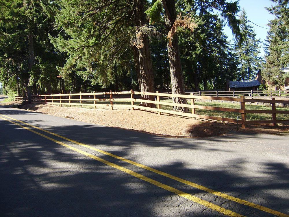 A sturdy wooden fence along the side of a road