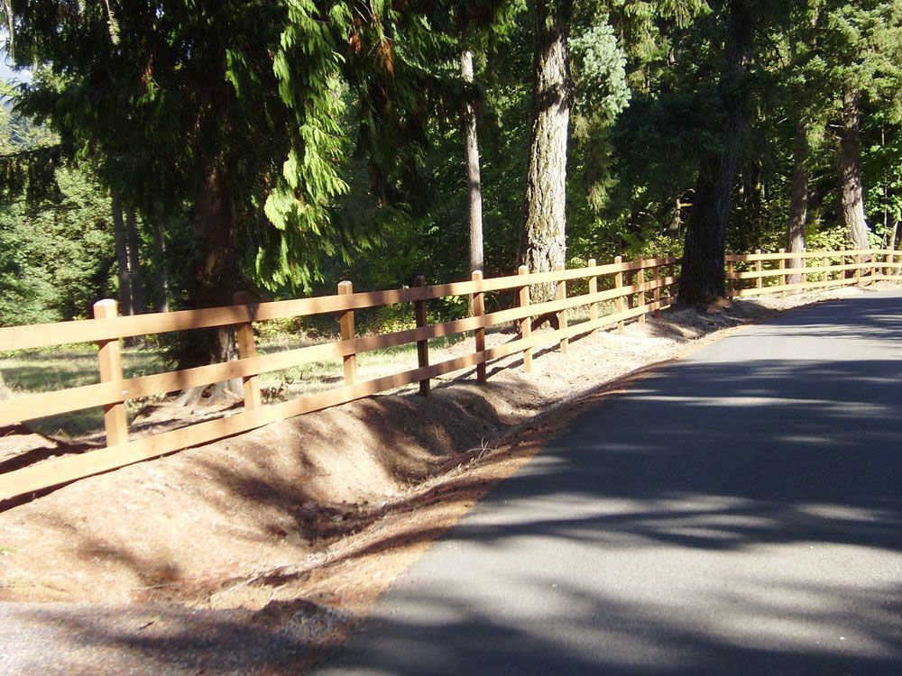 A well-built wooden fence along the side of a road