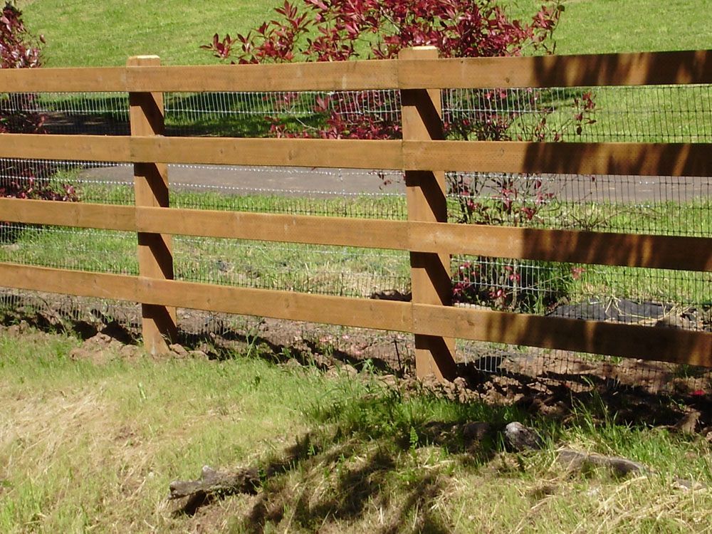 A wooden fence with a wire fence behind it