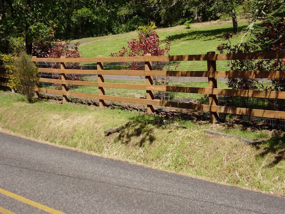A well-built fence along the side of a road