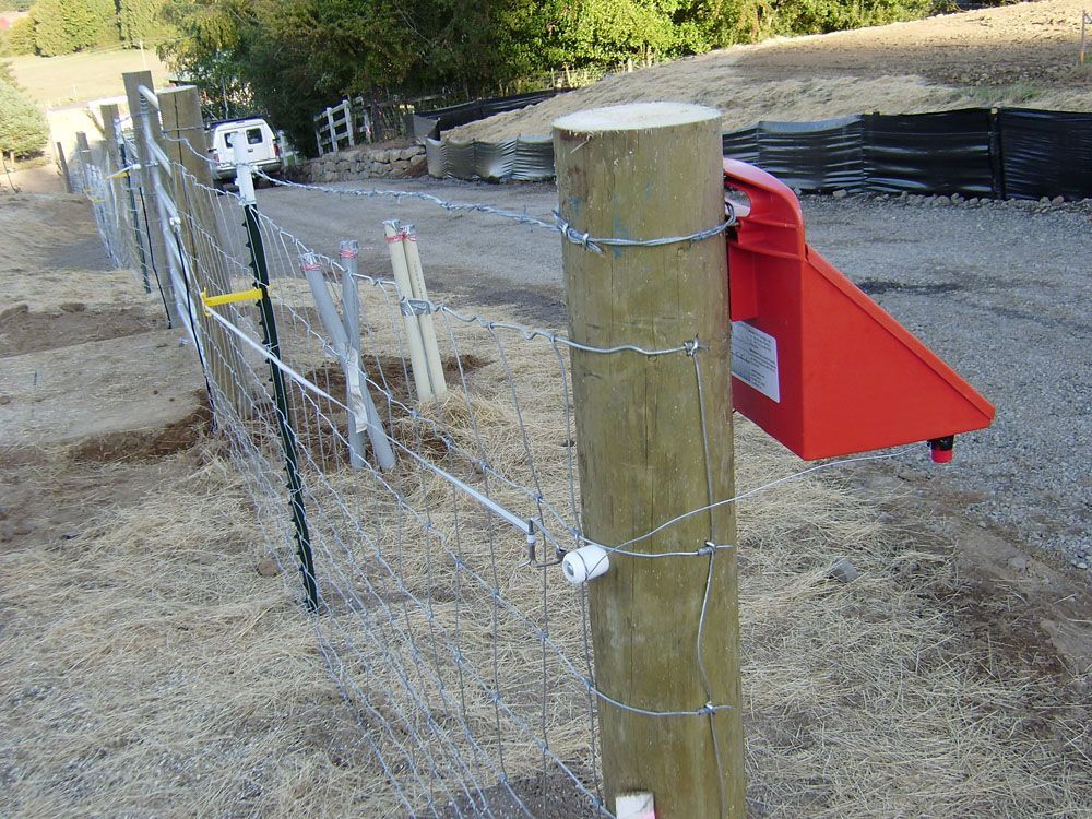 A wooden post with a red box attached to it