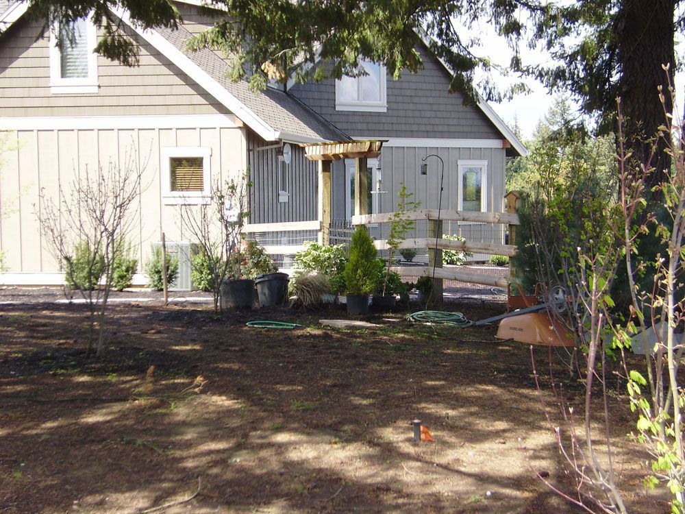 A house with a fence and trees in front of it