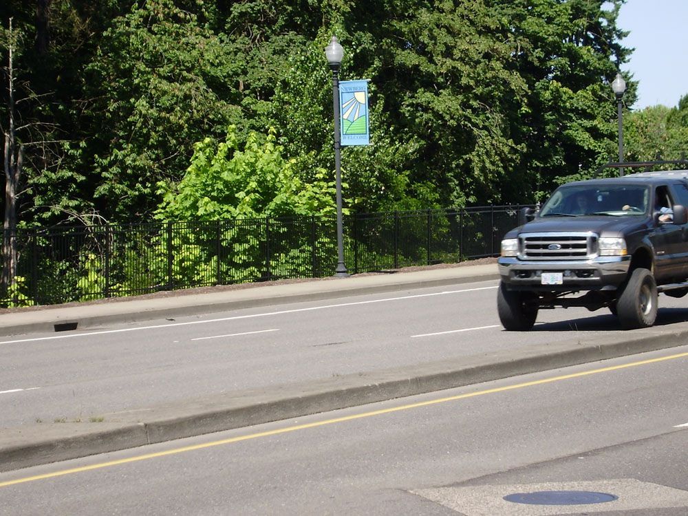A ford truck is driving down a street with trees in the background