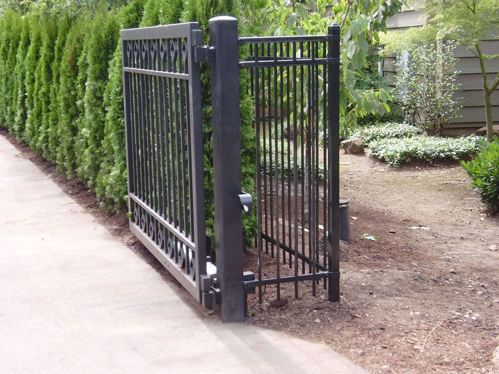 A black gate with a fence behind it