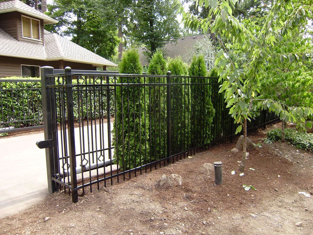 A black fence with a gate in front of a house
