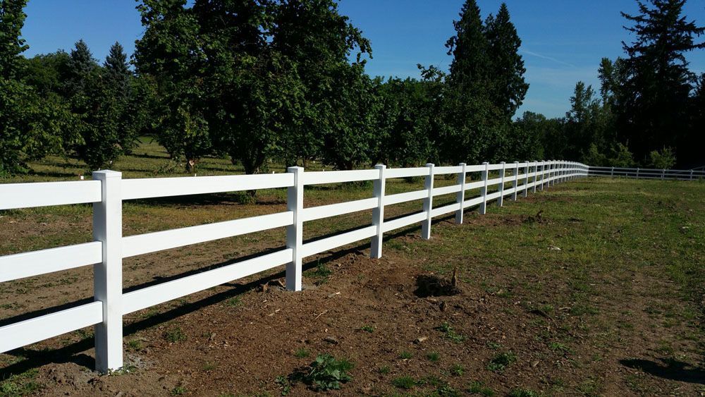 A white fence surrounds a grassy field