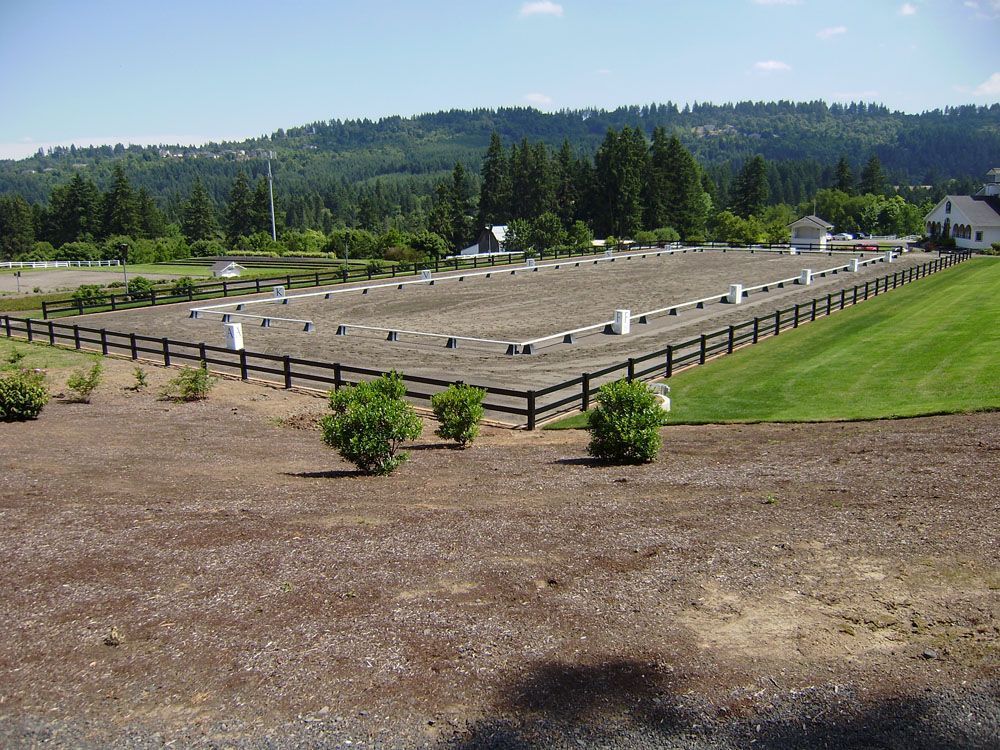 A fenced in field with a house in the background