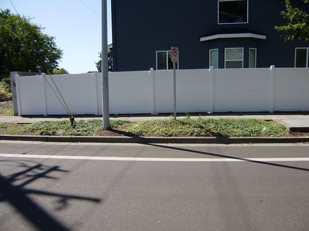 A blue house with a white fence and a no parking sign