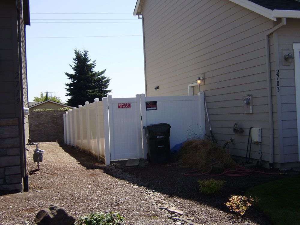 A white fence with a warning sign on it