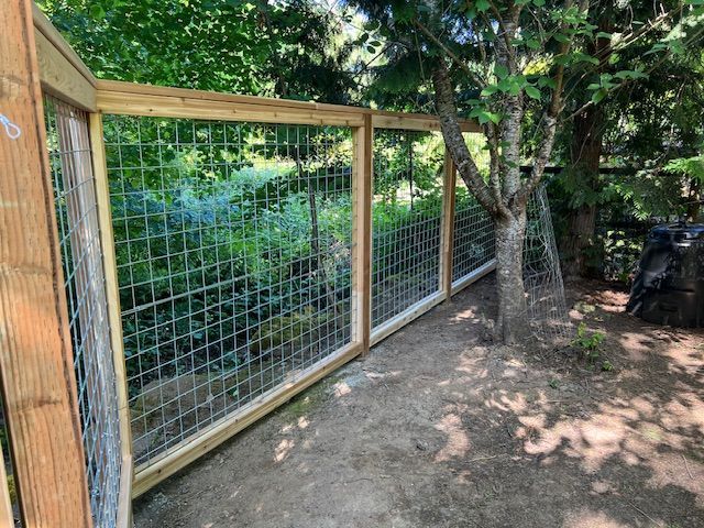 A wooden fence with a wire fence in the backyard
