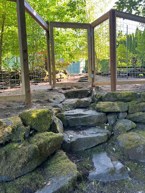 Rocks and moss surround a wooden fence