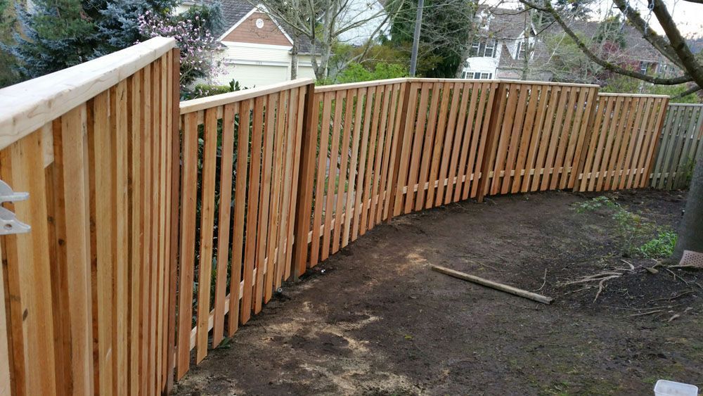 A wooden fence is being built in a backyard