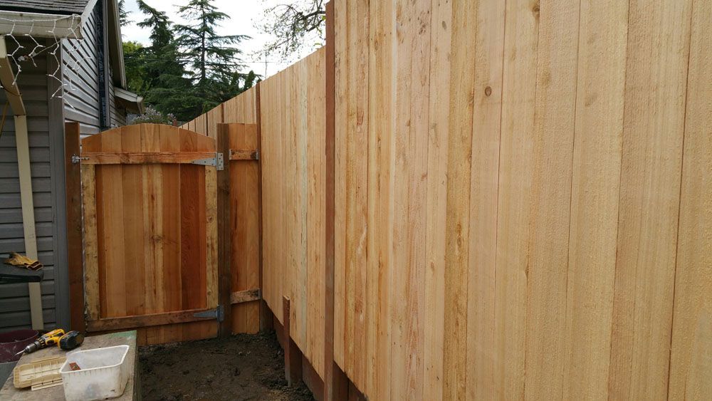 A wooden fence is being built next to a house