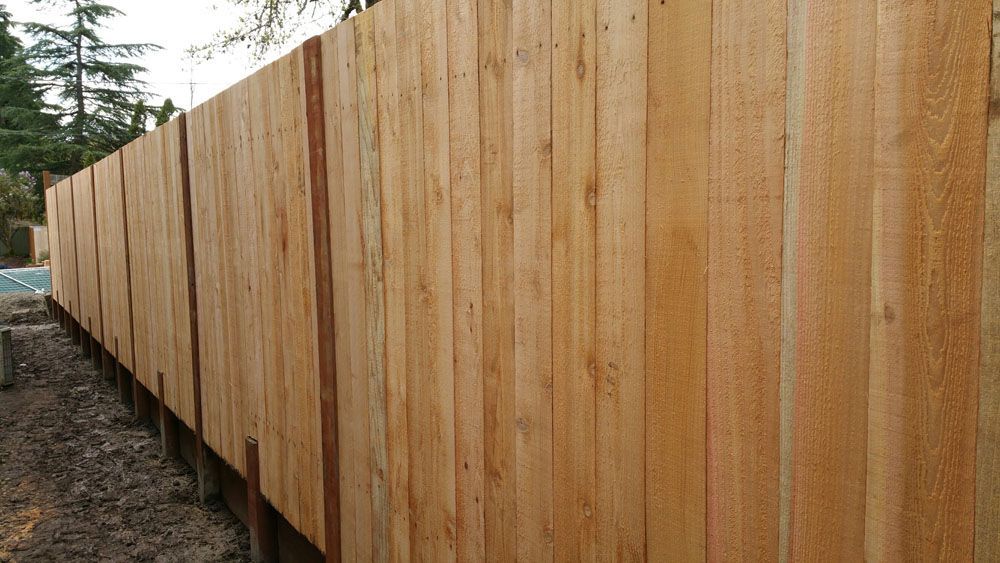 A wooden fence is sitting on top of a dirt field