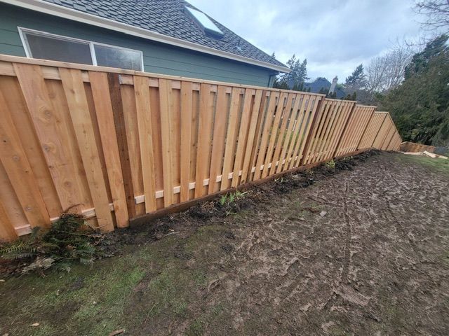 A wooden fence is in the backyard of a house