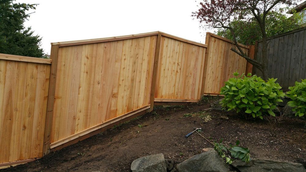 A wooden fence is sitting on top of a dirt hill