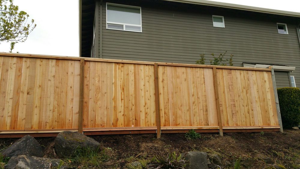 A wooden fence is sitting in front of a house