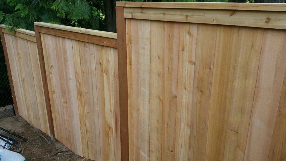 A wooden fence is sitting on top of a dirt field