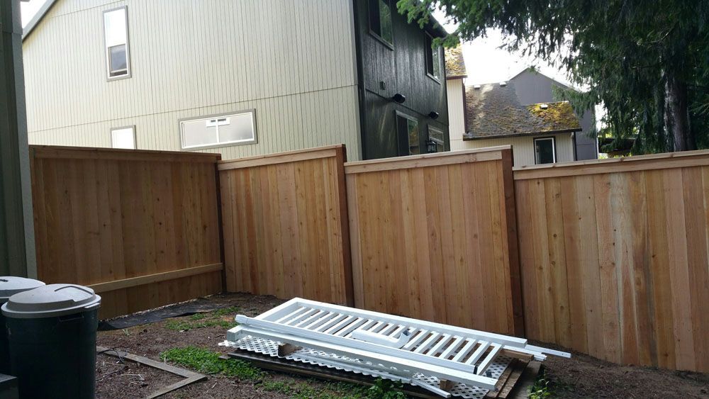 A wooden fence with a stack of stairs in front of it