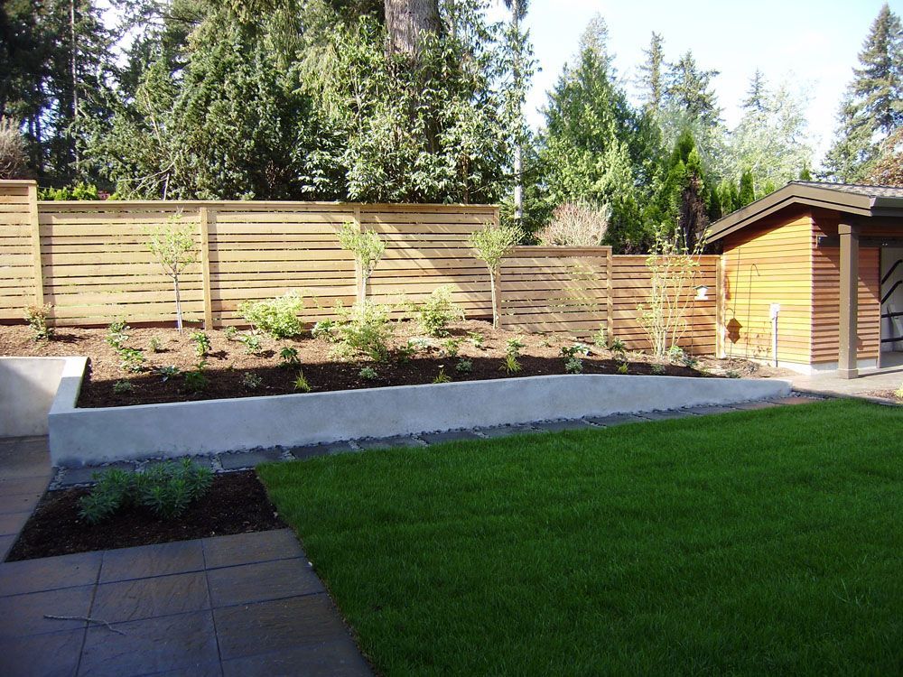 A backyard with a wooden fence and a shed