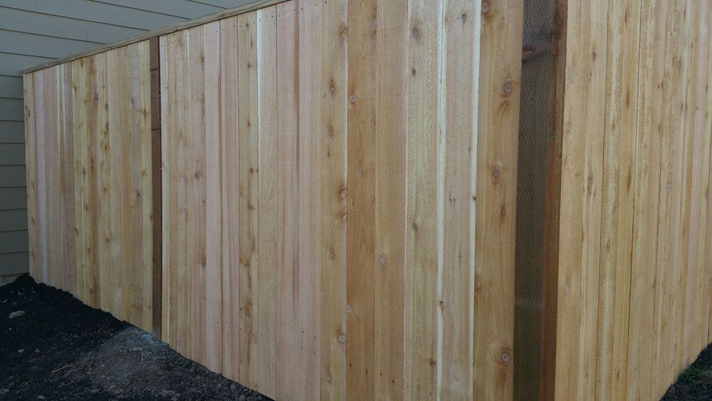 A wooden fence is sitting next to a house