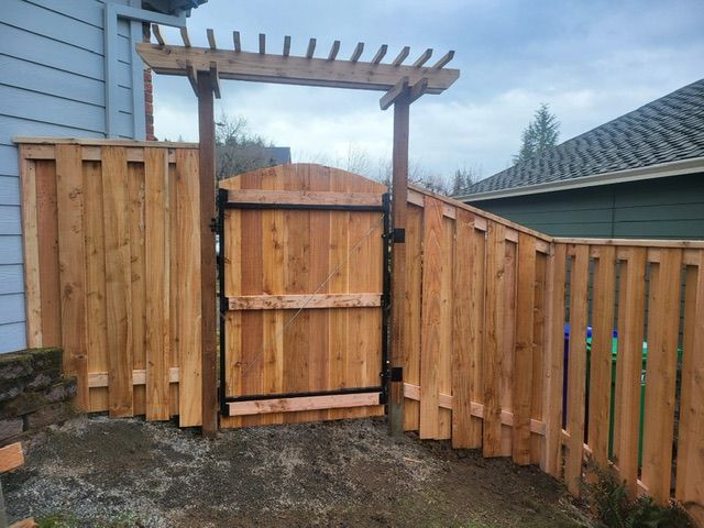 A wooden fence with a gate in the middle of it