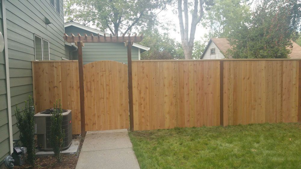 A wooden fence is in the backyard of a house