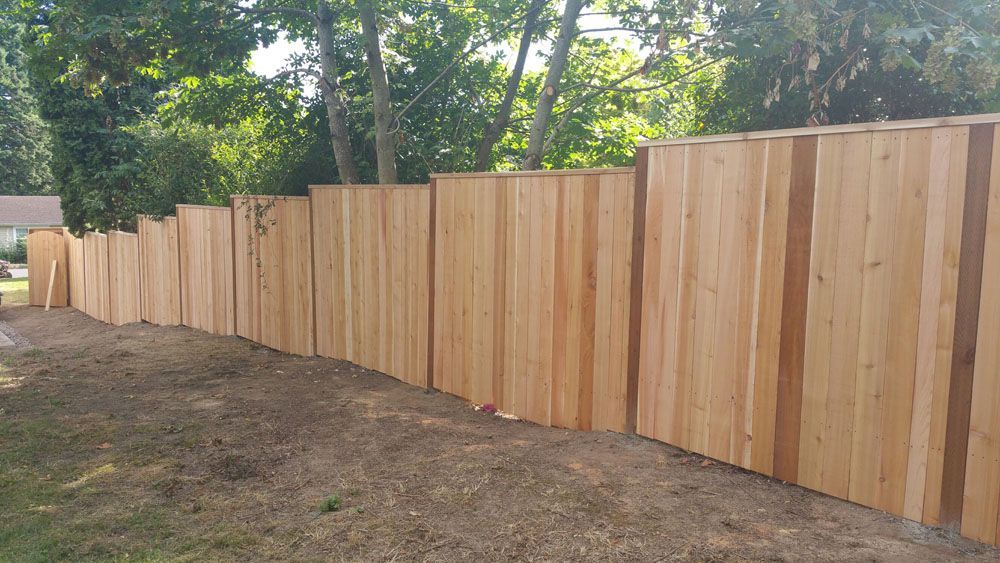 A wooden fence is sitting in the middle of a dirt field