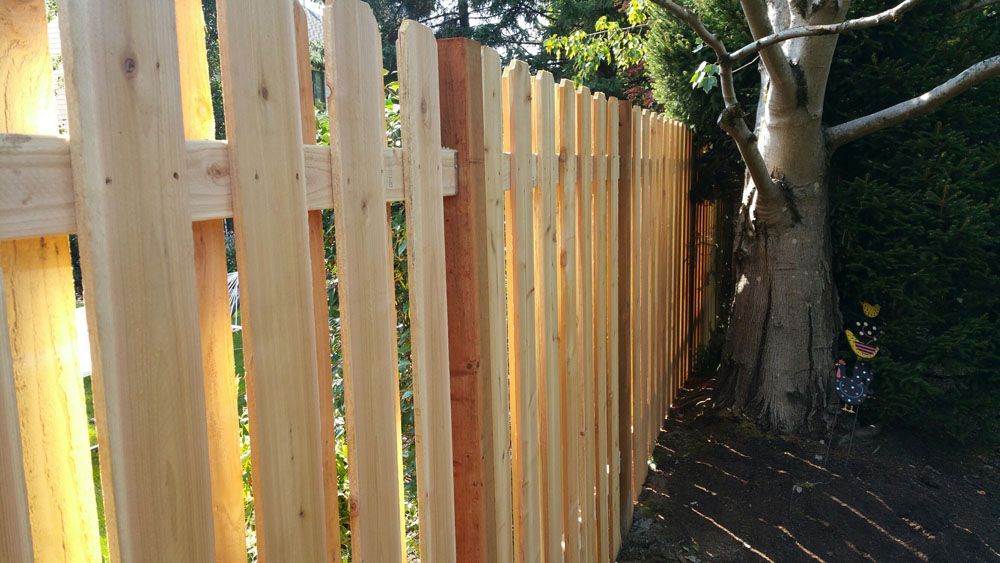 A wooden fence with a tree in the background
