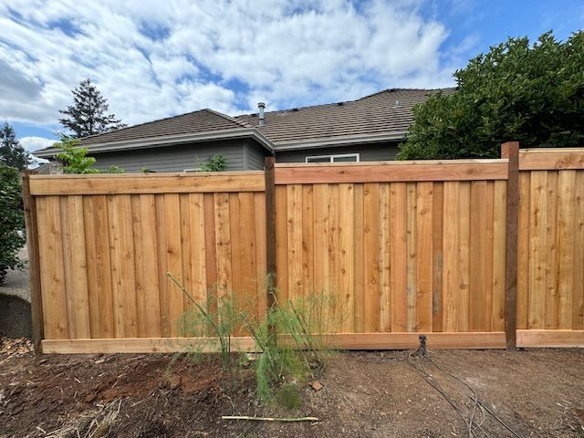 A wooden fence is sitting in front of a house