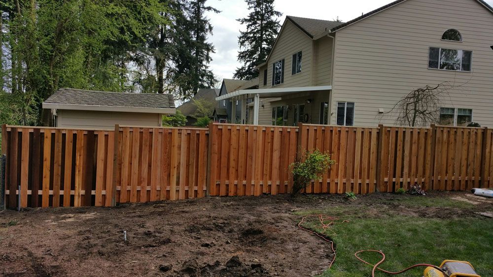 A wooden fence is being built in front of a house