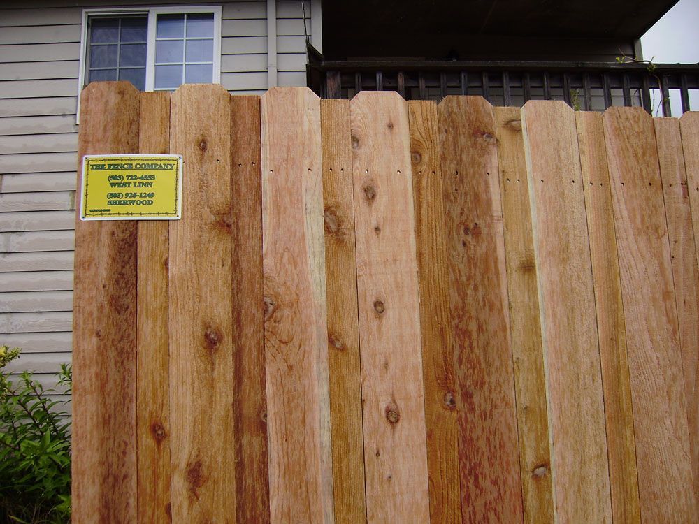 A wooden fence with a yellow sign on it
